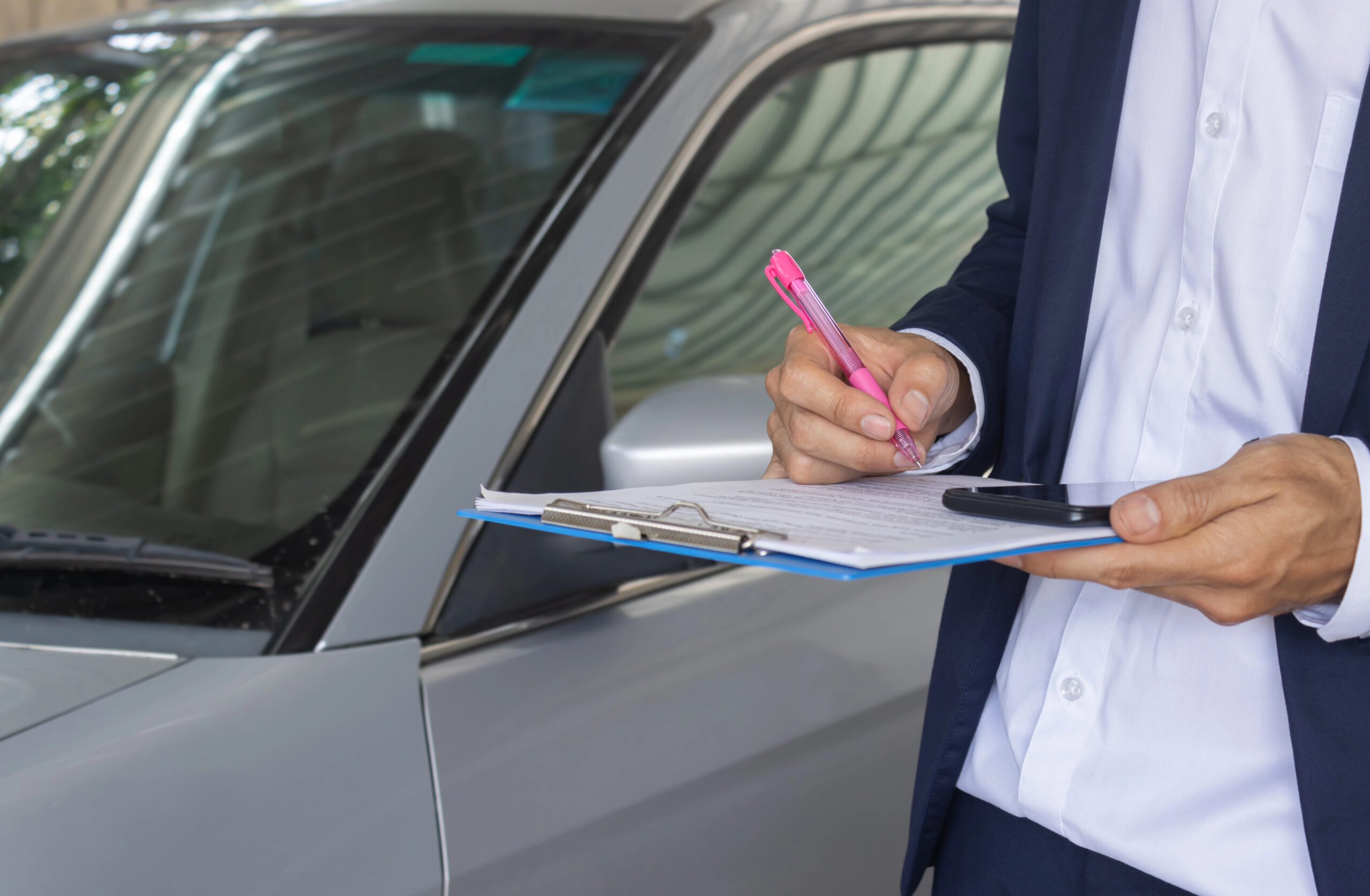 Car finance signing contract showing person finalising vehicle loan paperwork