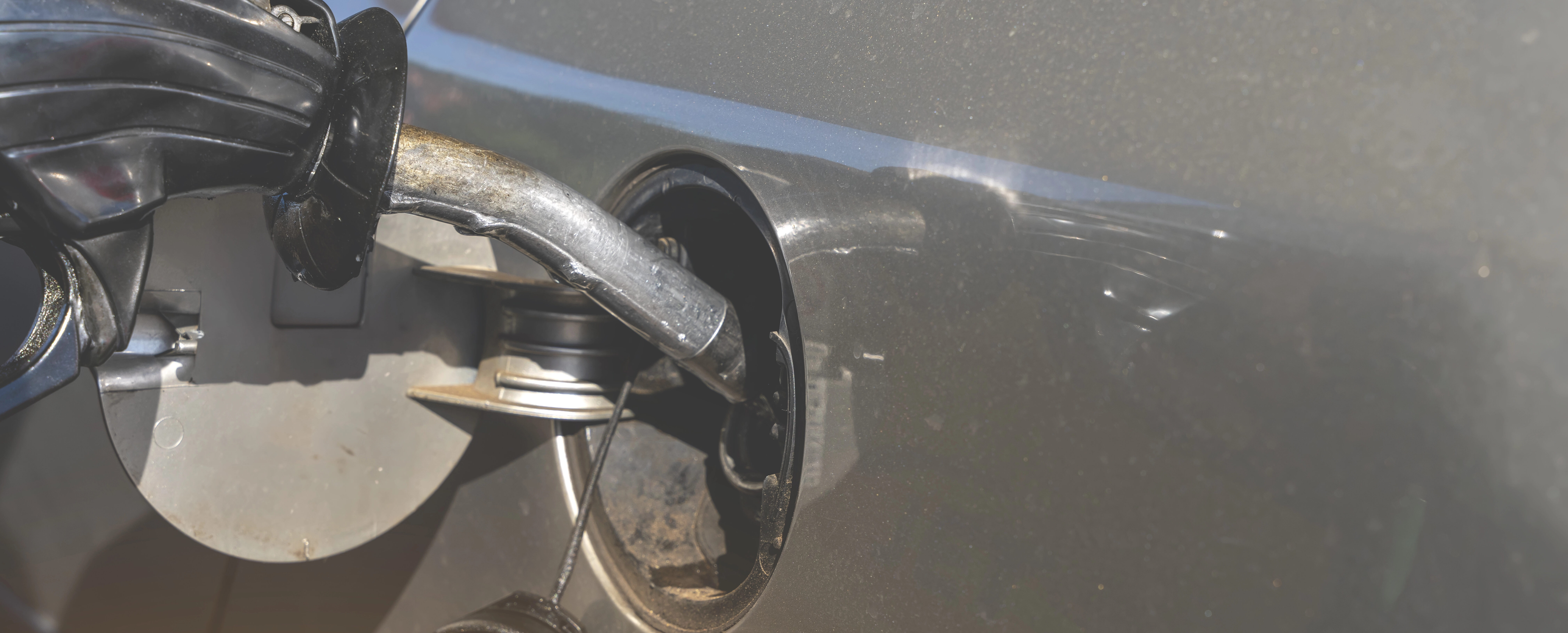 Diesel fuel nozzle inside car fuel tank with open cap