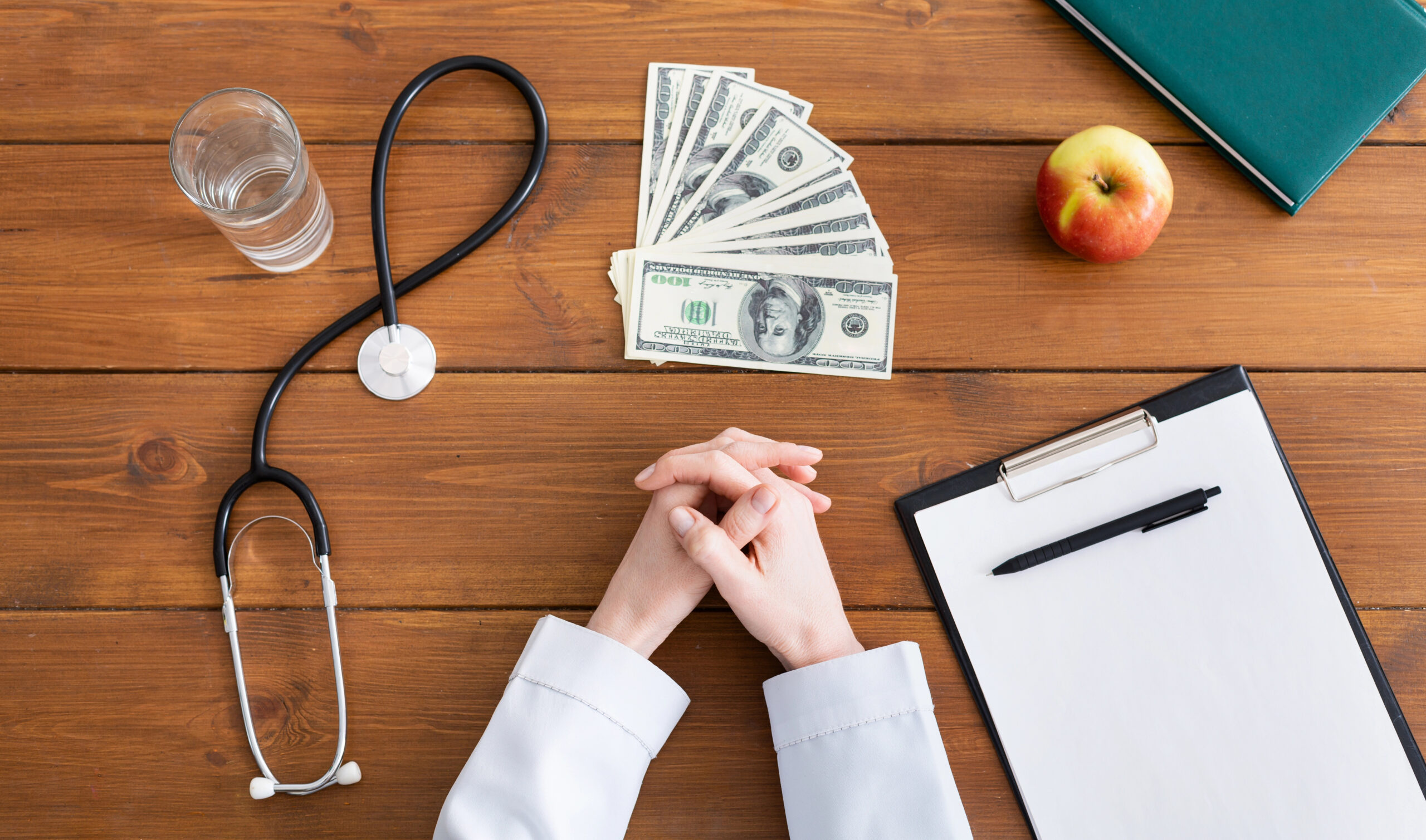 Health plan expenses illustrated by doctor with money on desk