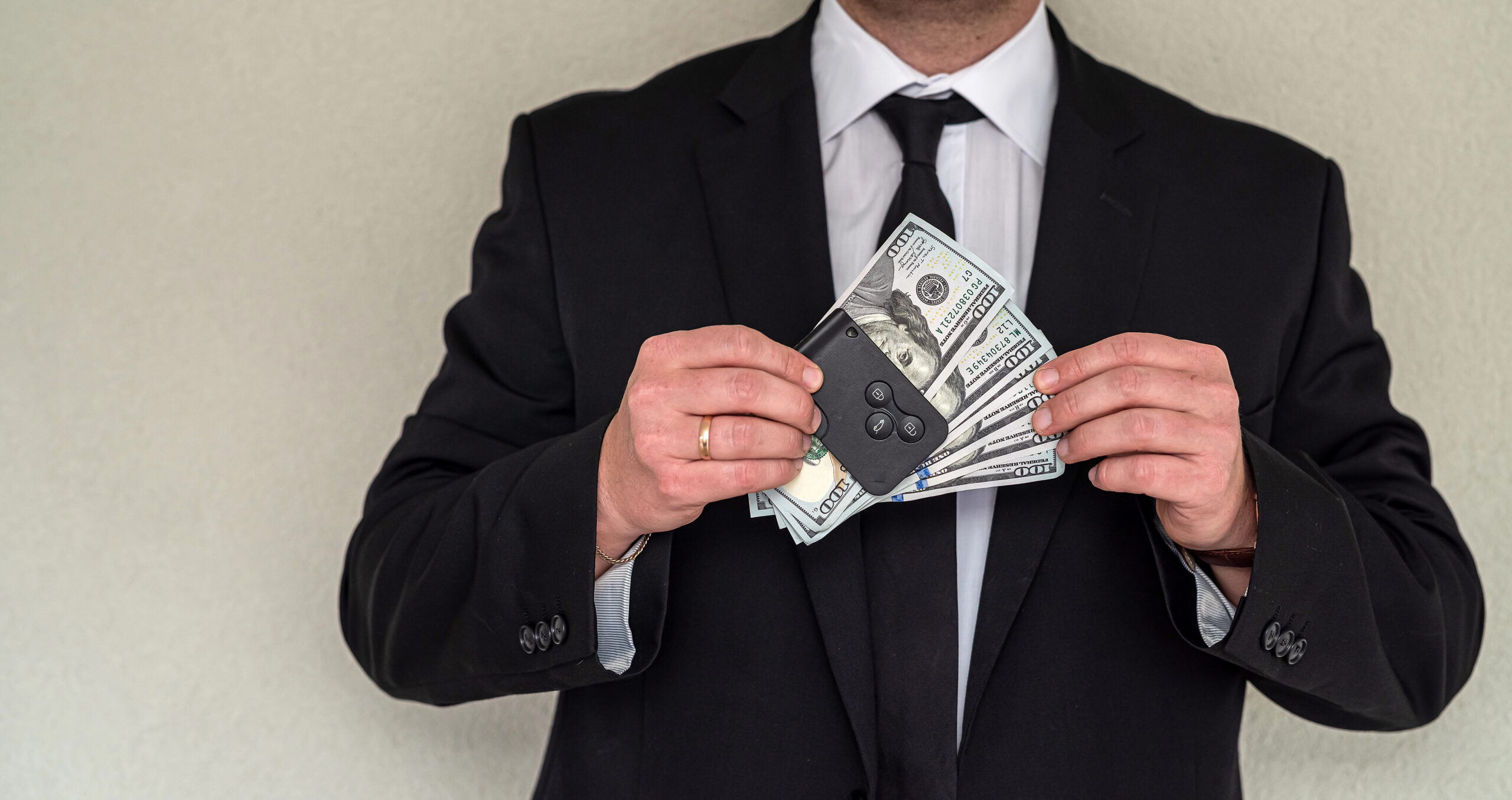 Man in a suit concealing cash linked to a Ponzi scheme in the UK
