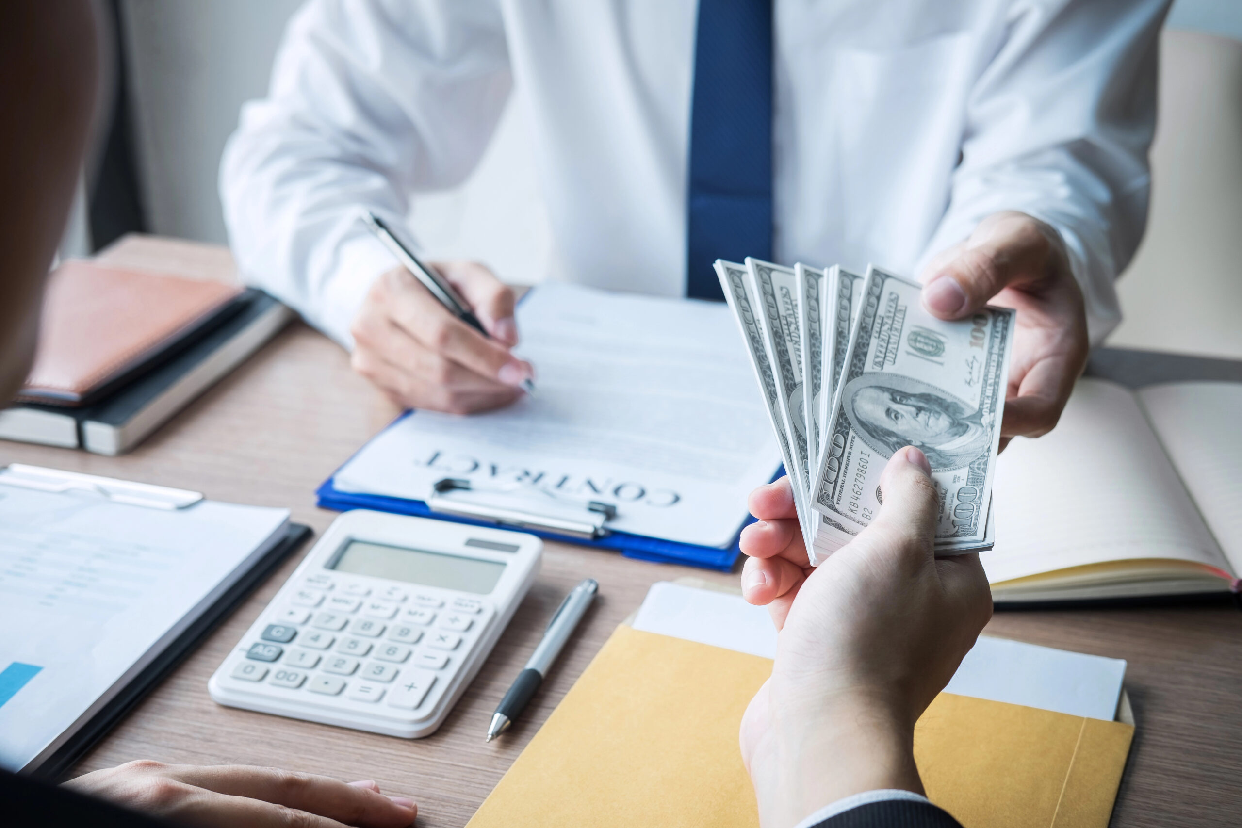 Cash payment in office highlighting UK unpaid wages and informal settlements
