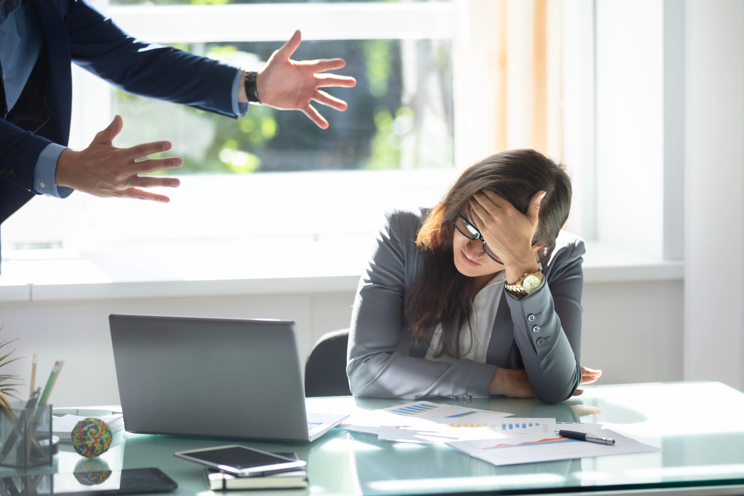 Stressed employee being scolded in office over unpaid wages in UK