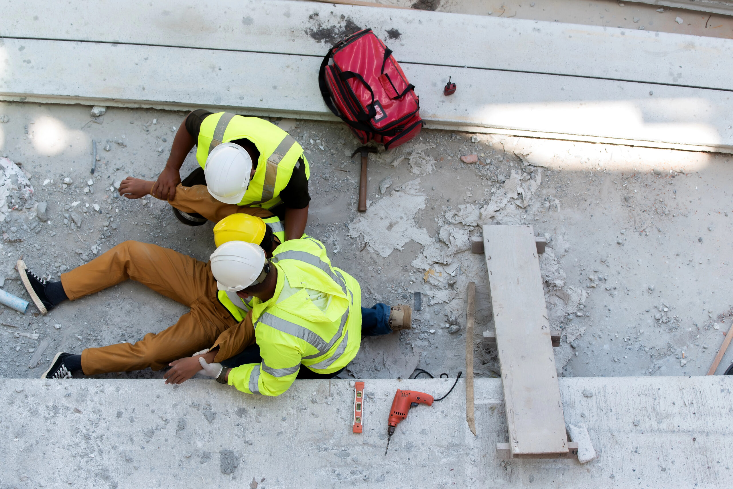Construction workers assisting an injured colleague after site accident